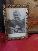 Portrait of a child with a retro toy in a gilded frame