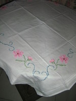 Beautiful cross stitch floral embroidered on white tablecloth