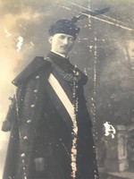 Old photo/postcard, portrait in fancy dress. The surface of the page is slightly damaged.