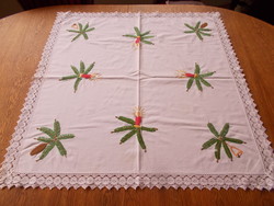 Embroidered Christmas tablecloth with a lace edge.