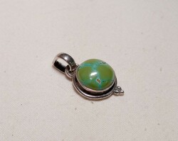 Old silver pendant with a large greenish turquoise