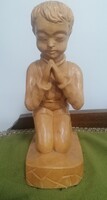 Carved wooden statue of a praying boy