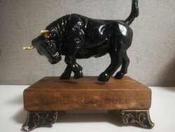 Black and gold horned cast iron bull, on a wooden base. 20 cm high