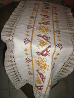 A beautiful folk traditional cross-stitch hand-embroidered tablecloth with a lace edge