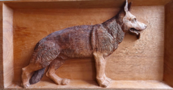 A wall picture of a German shepherd made of wood carving