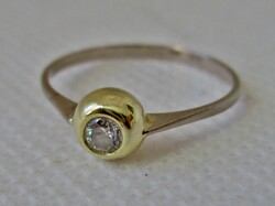Elegant 18kt gold ring with a white stone in a button setting