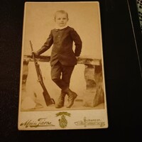 Photo of a small child with a rifle in his hand