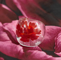Transparent glass ring with a red flower pattern inside