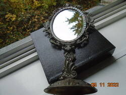 Bronzed table tilting mirror marked with an openwork relief baroque frame