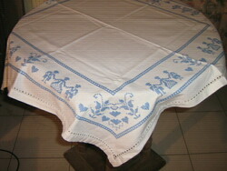 Beautiful hand embroidered azure blue motif on white tablecloth