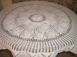 A beautiful hand-crocheted white tablecloth with a flower pattern