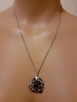 Showy silver necklace with an onyx stone heart pendant in a silver frame, decorated
