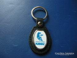 Kamaz oval metal keychain on a leather background