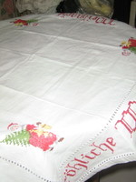 A charming white woven tablecloth with Santa Claus in azure cross stitch