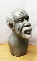 Gray granite African distorted statue. With a graying native figure