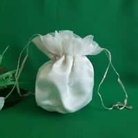 New, ecru-colored ruffled satin bridal gown, small bag