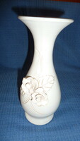 Slender white ceramic vase with raised rose