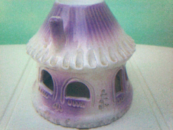 Pale purple candlestick round house with thatched roof