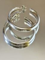 A pair of larger silver hoop earrings with a clean shape