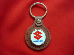 Suzuki metal keychain on a leather background