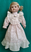 Old porcelain head blonde hair doll with a dreamy look, together with a stand