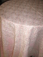 Pink elegant tablecloth richly embroidered with white fabric