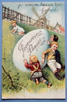 Antique embossed Easter greeting card for children with a huge egg rolling down a slope