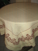A beautiful hand-embroidered, lined woven tablecloth with a crocheted edge