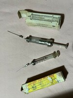Old glass syringes with metal needles and their boxes