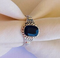 Silver ring with dark blue topaz stone.