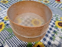 A small sieve or strainer with an old wooden frame
