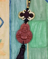 Real room. Rosewood pendant, amulet, laughing Maitreya Buddha