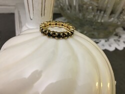 A silver ring with a symbol of endless love, beautifully crafted, surrounded by onyx stones in gold
