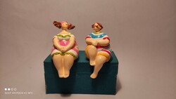 A charming pair of seated statues on a shelf