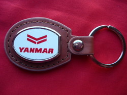 Yanmar metal keychain on a leather background