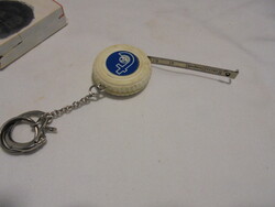 Retro savings association inscription, car tire-shaped keychain with measuring tape