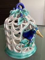 Zsuzsa Morvay's bird sitting in a cage in the iconic blue-green shade, openwork ceramic surface.