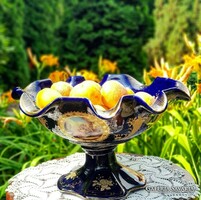 A beautiful cobalt blue serving bowl with a stand on the outside and inside