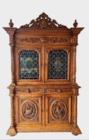 Antique, richly carved renaissance style sideboard with a hunting scene