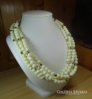 3 rows of pale butter-colored acrylic pearls with golden spacers, eye-catching.