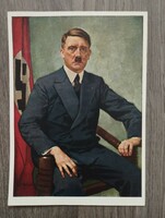 Adolf Hitler (1889-1945) / portrait, sitting on a chair next to the swastika flag, knee piece