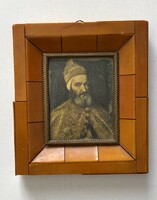A print of an antique painting of a male portrait of Titian in an amber-colored ornate frame