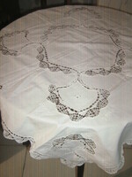 A beautiful white filigree tablecloth with a sewn insert with a lace edge
