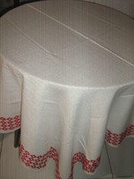 Beautiful filigree woven tablecloth with a red patterned edge
