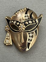 Farsangi maszk alakú bross matt arany színben fekete zománccal és kristályokkal díszítve