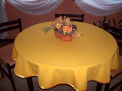 Okkor sárga terítő, 145 cm átmérőjű kör alakú, ferde pánttal szegve.