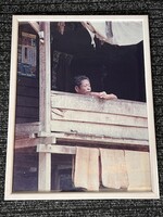 Ázsiai nyaralás keretezett életképe faház tornácán dohányzó tibeti férfi portré