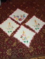 Kézi hímzésű terítő a magyar népművészet hagyományos motívumait mutatja be,