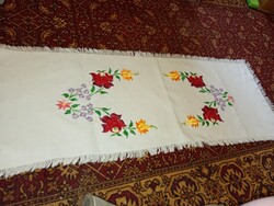 Kézi hímzésű terítő a magyar népművészet hagyományos motívumait mutatja be,