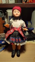 Retro old doll in traditional folk costume made of plastic